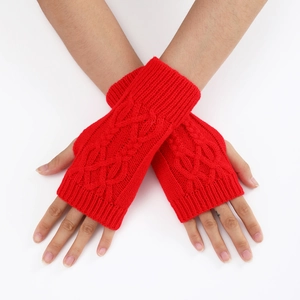 Détail de mitaines rouges en maille torsadée montrant la texture et le motif tressé