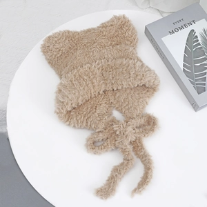 Detail of plush cat ear knit hat with long tassels in soft beige faux fur material