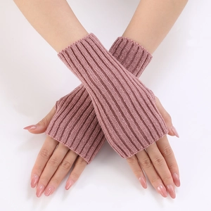 Detailed knit texture of pink ribbed fingerless gloves with thumb hole on wrist
