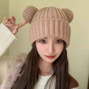 Close-up of light brown knitted beanie with cute bear ears and ribbed texture detail