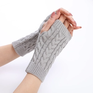 Detail of grey cable knit fingerless gloves showing thick texture and thumb hole design