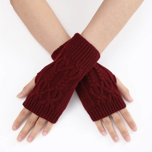 Détail de mitaines en tricot torsadé rouge foncé avec trou pour le pouce pour l'hiver