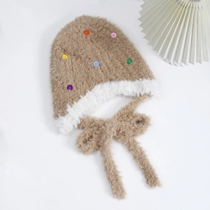 Dettaglio di un caldo berretto di peluche con bottoni colorati e bordo in finta pelliccia bianca