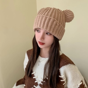 Close-up of caramel knitted beanie with cute bear ears and thick thermal texture