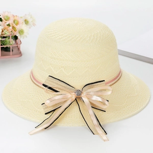 Close-up of beige woven straw sun hat with striped bow and crystal flower detail