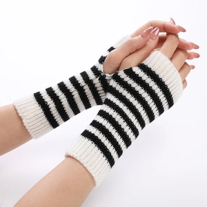 Close-up of black and white striped knitted fingerless gloves with thumb hole detail
