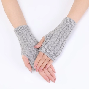 Close-up of light gray knitted arm warmers with classic vertical cable patterns