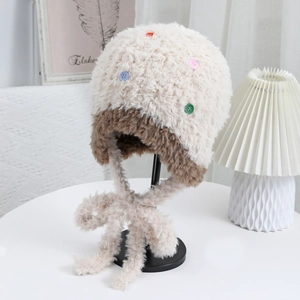 Dettaglio del cappello in peluche con bottoni colorati e morbida trama lavorata