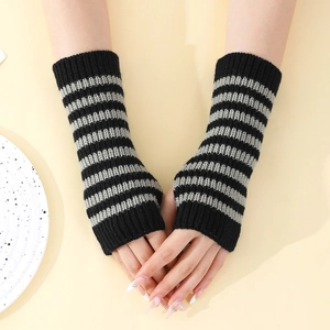 Macro detail of knit striped fingerless gloves with thumb hole in black and gray