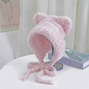 Detail of pink faux fur hat with bear ears and long straps on a professional display stand