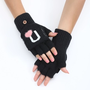Détail de gants en tricot noir avec cœur en peluche rose et bouton en bois décoratif