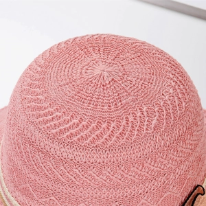 Detailed macro view of pink sun hat featuring intricate spiral woven straw texture