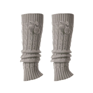 Detalle de calentadores grises de punto con trenzas y pompones suaves de invierno