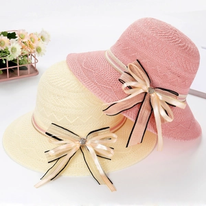 Detail of woven sun hats featuring ribbon bows and sparkling crystal flower centers