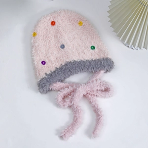 Dettaglio del cappello in peluche con bottoni colorati e morbida pelliccia sintetica