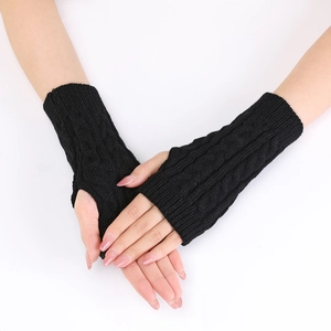 Detail of black cable-knit arm warmers with fingerless design for warmth and style