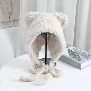 Detailed texture of plush cream knit hat with bear ears and warm chin straps