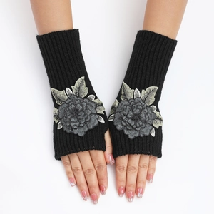 Détail de mitaines en tricot noir avec broderie florale élégante et texture côtelée