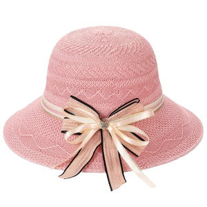 Pink woven sun hat for women with a decorative bow and heart rhinestone on a white background