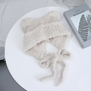 Close-up of soft beige plush cat ear hat with long tassels and furry knit texture