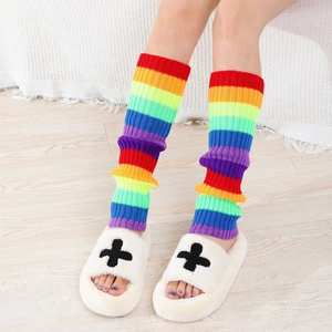 Detailed knit texture of rainbow striped y2k leg warmers styled with plush slippers