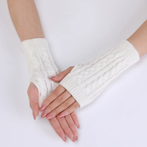 Detail of white cable knit arm warmers showing thick braided texture and fingerless design