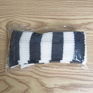 Gros plan de jambières en tricot rayées noir et blanc avec texture côtelée en emballage