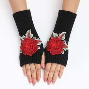Détail de mitaines noires en tricot avec élégante broderie florale de roses rouges