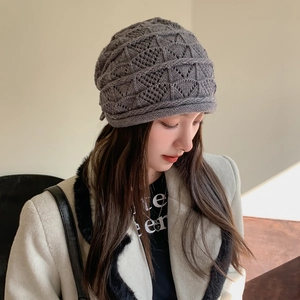 Dettaglio della maglia traforata a rombi e del bordo spesso arrotolato sul cappello