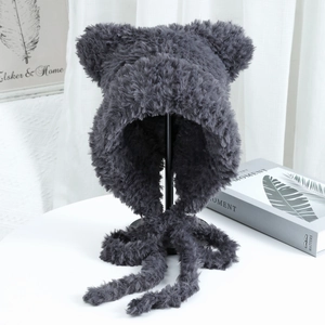 Detail of dark grey plush hat featuring bear ears and long ties for winter warmth