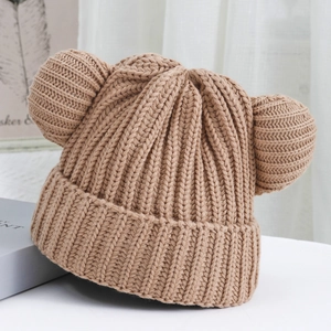 Detail of light camel knit beanie with cute bear ears and thick ribbed texture design