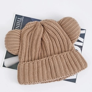 Close-up of thick knitted texture and cute bear ears on the khaki winter beanie hat