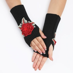 Détail de broderie florale rouge sur des mitaines en tricot noir pour femmes