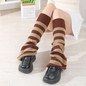Detailed knit texture of brown and beige striped leg warmers with chunky black shoes