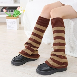 Detailed knit texture of brown striped leg warmers paired with black leather shoes