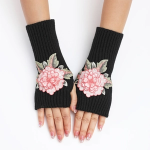 Détail de la broderie florale rose sur les mitaines tricotées noires pour femmes