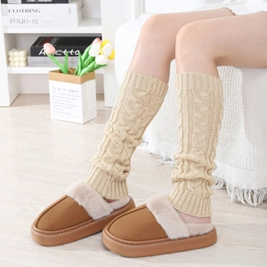Detail of beige cable knit leg warmers paired with cozy fleece-lined platform slippers