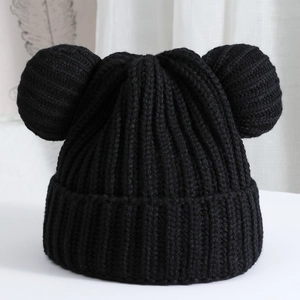 Detailed close-up of a black knit hat with cute round ears and thick textured ribs
