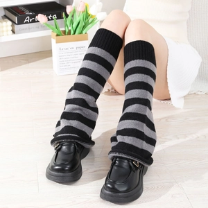 Detail of black and grey striped knit leg warmers with ribbed cuffs and platform shoes