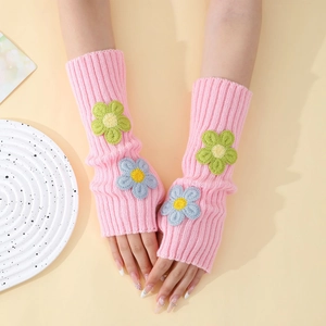 Close-up of pink knitted fingerless gloves with 3D floral embroidery and ribbed texture