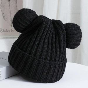 Close-up of black knitted beanie featuring thick ribbed texture and cute bear ear details