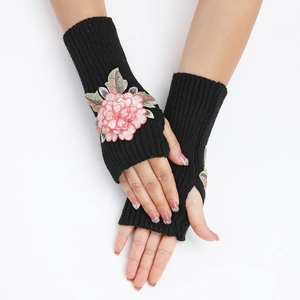 Gros plan détaillé de la broderie florale rose sur mitaines en maille noire