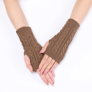 Macro detail of brown cable knit arm warmers with thumb holes and textured wool pattern