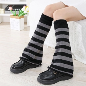 Detail of black and grey striped knit leg warmers with flared opening and loafers