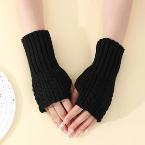 Détail de la maille torsadée sur des mitaines noires en tricot pour femmes
