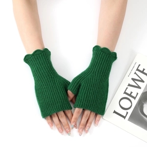 Close-up of dark green ribbed knit fingerless gloves with elegant wavy ruffled edges