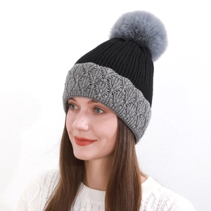 Dettaglio del cappello invernale in maglia bicolore grigio e nero con grande pompon