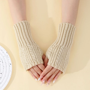 Détail du tricot torsadé des mitaines beiges montrant la texture et le trou du pouce