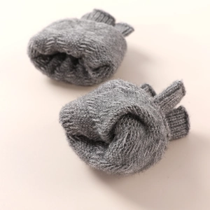 Close-up of gray knit fingerless arm sleeves showing warm chunky wool texture
