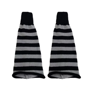 Detailed knit texture of black and grey striped leg warmers with ribbed cuffs